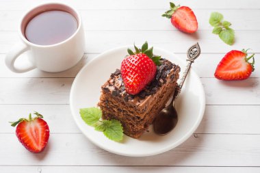 Beyaz ahşap bir masa üzerinde çikolata ve çilek ve nane ile Trüf kek. Seçici odaklama.