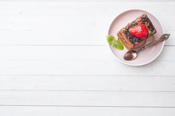 Bolo de trufa com chocolate e morangos e hortelã em uma mesa de madeira branca. Foco seletivo. Espaço de cópia — Fotografia de Stock