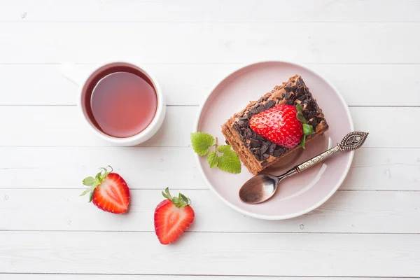 Truffle cake with chocolate and strawberries and mint on a white wooden table. Selective focus. Copy space