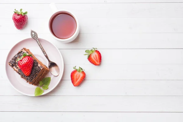 Pastel de trufa con chocolate y fresas y menta en una mesa de madera blanca. Enfoque selectivo. Copiar espacio — Foto de Stock
