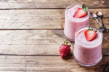 Ahşap bir arka plan üzerinde gözlük taze çilek ile ev yapımı yoğurt. Seçici odak. Kopyalama alanı.