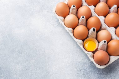 Gri arka plan üzerinde fabrika ambalaj Kahverengi çiğ Tavuk yumurtası. Kopyalama alanı