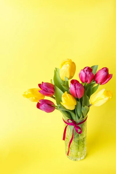 Ramo de tulipanes amarillos y rosados sobre fondo amarillo. Copiar espacio —  Fotos de Stock