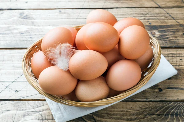 Friss csirke tojást a kosárba. Rusztikus fa stílusban háttér. — Stock Fotó