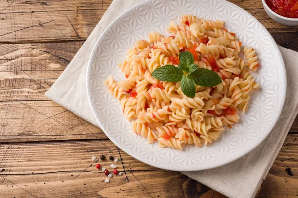 Pastas en espiral mezcladas con tomates cherry y salsa de tomate en un plato . — Foto de Stock