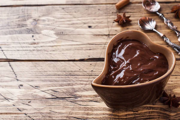 Chocolate paste with cinnamon and anise. Fondue with chocolate on a wooden table. copy space