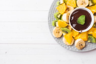 Beyaz masada meyve ile çikolata fondü. kavram yaz partisi. Kopyalama alanı