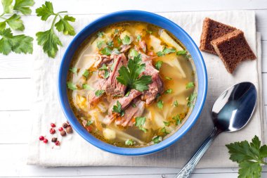 Rus geleneksel lahana çorbası et ve masa lambası üzerinde taze otlar ile.