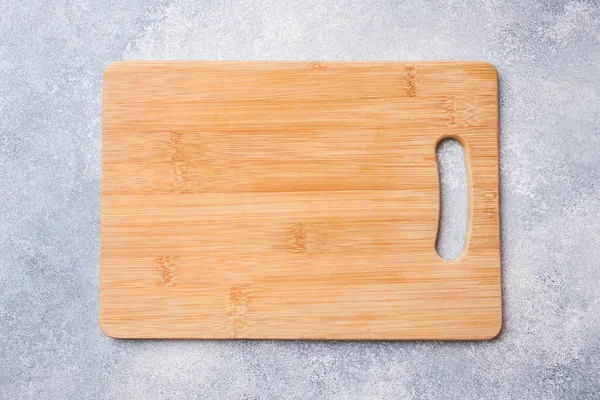 Pusta drewniana deska do krojenia na stole kuchennym. Obszar kopiowania w widoku z góry — Zdjęcie stockowe