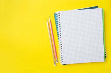 Sunum, yazar veya okul eğitimi, blogger, roman ve sürtünme veya marka hikayesi konsepti için sarı masa arka plan üzerinde kopya alanı ile temiz beyaz defter ve kalem.