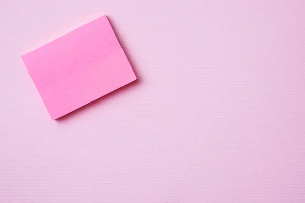 Blocco note rosa graffetta e matita su sfondo rosa con spazio per la copia. Concetto di istruzione scolastica, ufficio e freelance . — Foto Stock