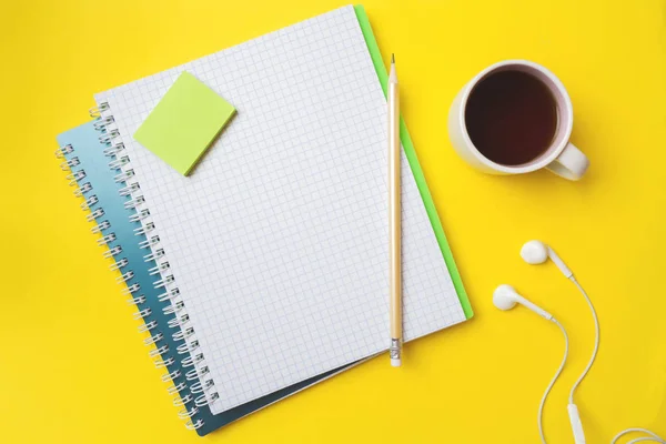 Clean white notebook and pencil Cup of coffee with copy space on yellow table background for presentation, writer or school education, blogger, novel and friction or brand story concept.