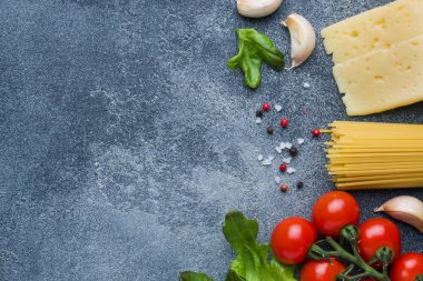 Ham İtalyan makarna spagetti ve malzemeyi kiraz domates peynir yeşillik yemek. İtalyan yemeği koyu taş arka plan. Kopya alanı ile Üstten Görünüm