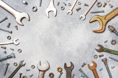 Kopya alanı ile gri beton zemin üzerinde anahtarlar, araçlar, civatalar ve fındıklar.