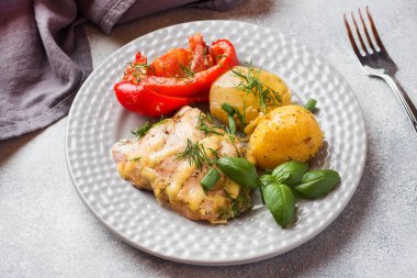 Bir tabakta tavuk ve sebze ile Fırında patates.