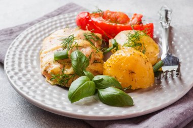 Bir tabakta tavuk ve sebze ile Fırında patates.