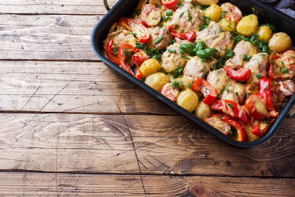 Coxas de frango cozidas no forno, batatas e verduras em uma bandeja de cozedura em uma mesa de madeira. Espaço de cópia . — Fotografia de Stock