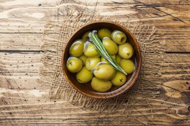 Tahta masa üzerinde ahşap kaselerde yeşil zeytin. Metin için alanla en iyi görünüm.