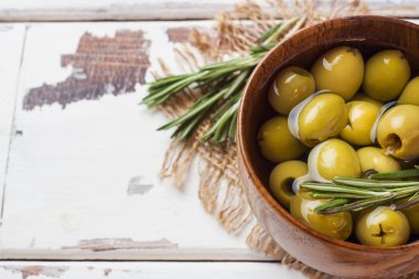 Tahta masa üzerinde ahşap kaselerde yeşil zeytin. Metin için alanla en iyi görünüm.