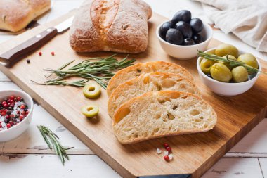 Ahşap bir Tahta üzerinde zeytin ve biberiye ile İtalyan ciabatta ekmek.