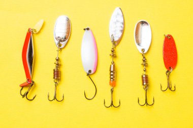 Balık kancaları ve yemler kopya alanı ile sarı bir arka plan üzerinde farklı balık yakalamak için bir dizi. Düz yatıyordu
