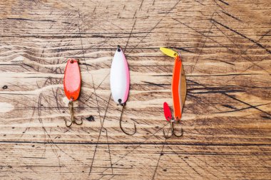 Balık kancaları ve yemler kopya alanı ile ahşap bir arka plan üzerinde farklı balık yakalamak için bir dizi. Düz yatıyordu