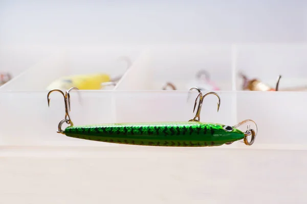 Fishing hooks and fish shaped lures on the box with copy space. Selective focus, — Stock Photo, Image
