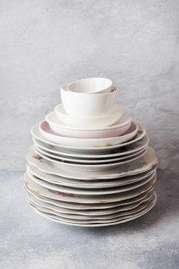 Boş tabakları kopyalama alanı olan gri bir masanın üzerine yığın.