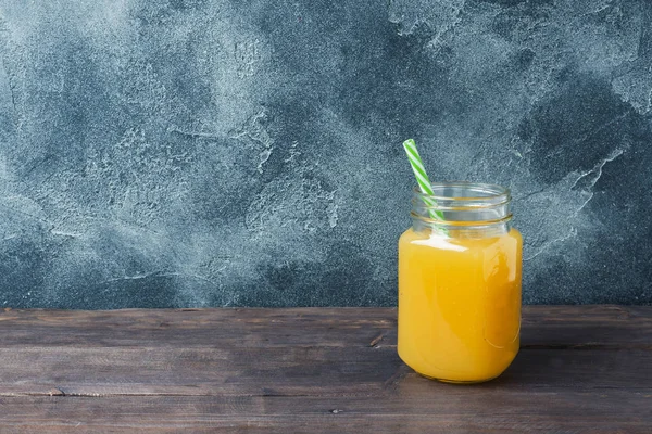 Orange juice in glass jar on dark background with copy space. — Stock Photo, Image