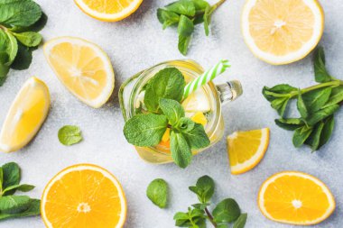 Limonata bardak maden suyu, limon ve nane kavanoza ışık arka plan üzerinde bırakır..