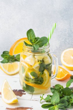 Limonata bardak maden suyu, limon ve nane kavanoza ışık arka plan üzerinde bırakır. Kopya alanı