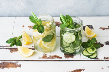 Sağlıklı yaşam için su detoks. Tatlı suda limon, salatalık ve ahşap masa nane kavanozu.