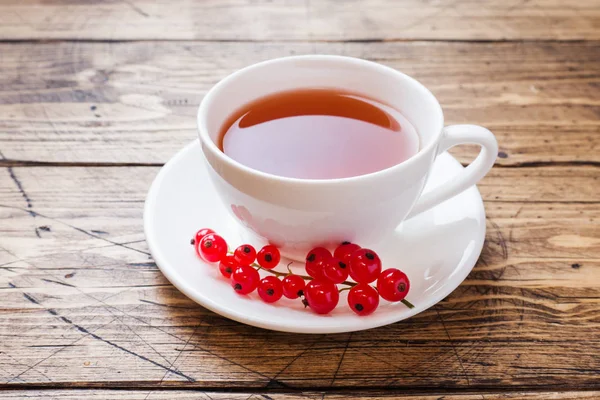 Φλιτζάνι τσάι και φρέσκα μούρα Κόκκινο φραγκοστάφυλο σε ξύλινο τραπέζι. Αντιγραφή χώρου. — Φωτογραφία Αρχείου