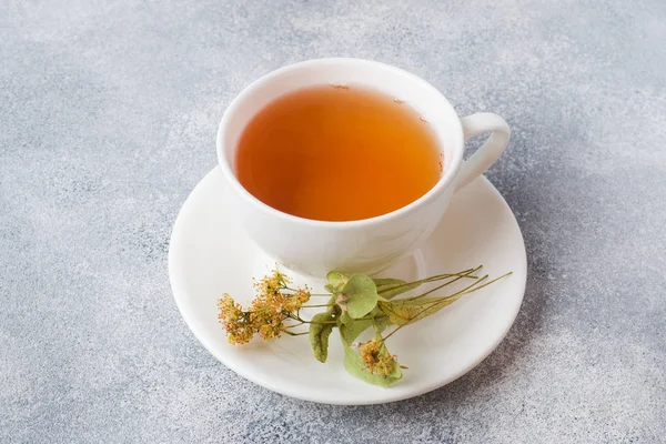 Tazza di tè verde e fiori tiglio su sfondo grigio. Copia spazio . — Foto Stock