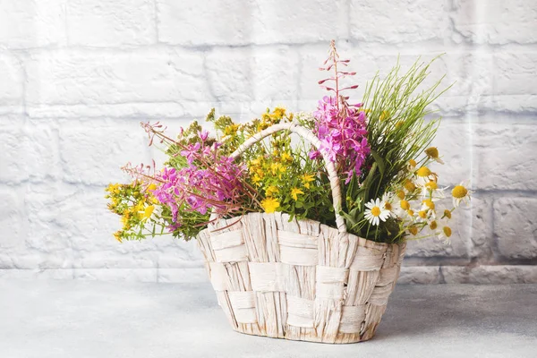 Bouquet of beautiful wildflowers in a basket on a gray background with copy space. — Stock Image Bouquet of beautiful wildflowers in a basket on a gray background with copy space. Royalty Free Stock Photos