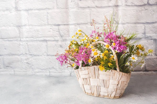 Bouquet of beautiful wildflowers in a basket on a gray background with copy space. — Stock Image Bouquet of beautiful wildflowers in a basket on a gray background with copy space. Stock Image