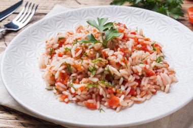 Pirinç ile domates sosu ve Yeşiller ahşap arka plan üzerinde.