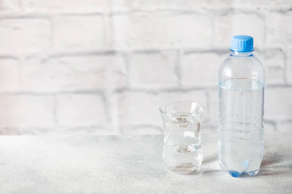Botol air transparan plastik pada latar belakang abu-abu dengan ruang fotokopi . — Stok Foto