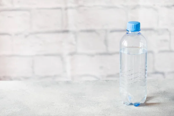 Botol air transparan plastik pada latar belakang abu-abu dengan ruang fotokopi . — Stok Foto