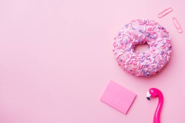 Pembe donut ve pembe arka planda Flamingo kalem. Üst Görünüm Düz.