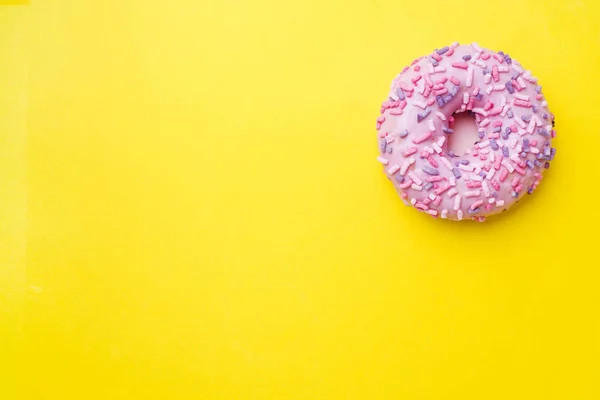 Beignet rose sur fond jaune. Vue du dessus Flat lay . — Photo