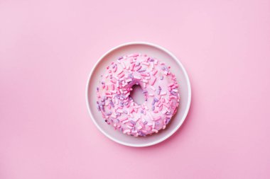 Pembe arka planda pembe çörek. Üstten düz yatıyordu.