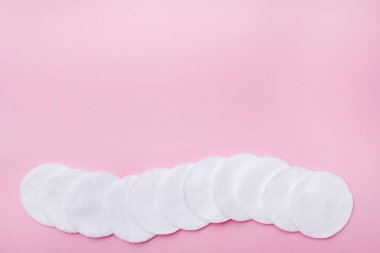 Pembe bir arka plan üzerinde pamuk yuvarlak bezler. Seçici odak Kopyalama alanı.