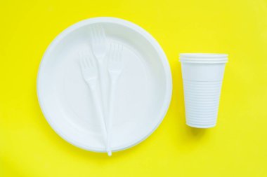 Kopya alanı ile parlak sarı arka planda tek kullanımlık plastik sofra.
