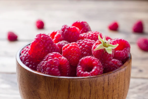 Свіжі червоні ягоди малини в дерев'яній тарілці . — стокове фото