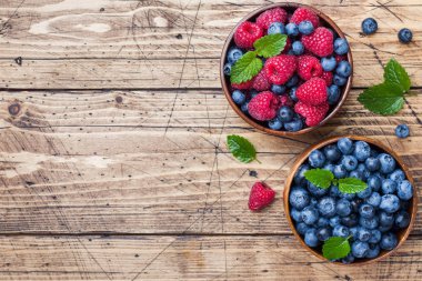 Ahşap bir tabakta taze ahududu ve yaban mersini.