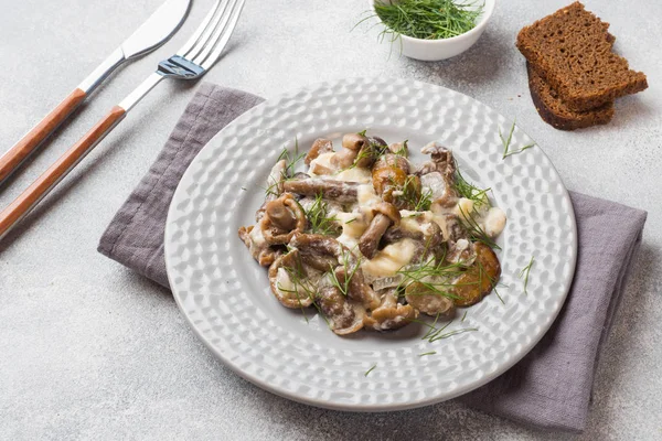Тушковані гриби в соусі зі сметаною та сиром на тарілці — стокове фото