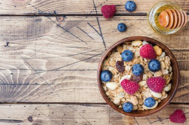 Sağlıklı kahvaltı. Taze granola, yoğurtlu müsli ve ahşap arka planda böğürtlen. Boşluğu kopyala.