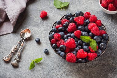Taze ahududu ve yaban mersini koyu arka plan üzerinde plaka. Kopyalama alanı.