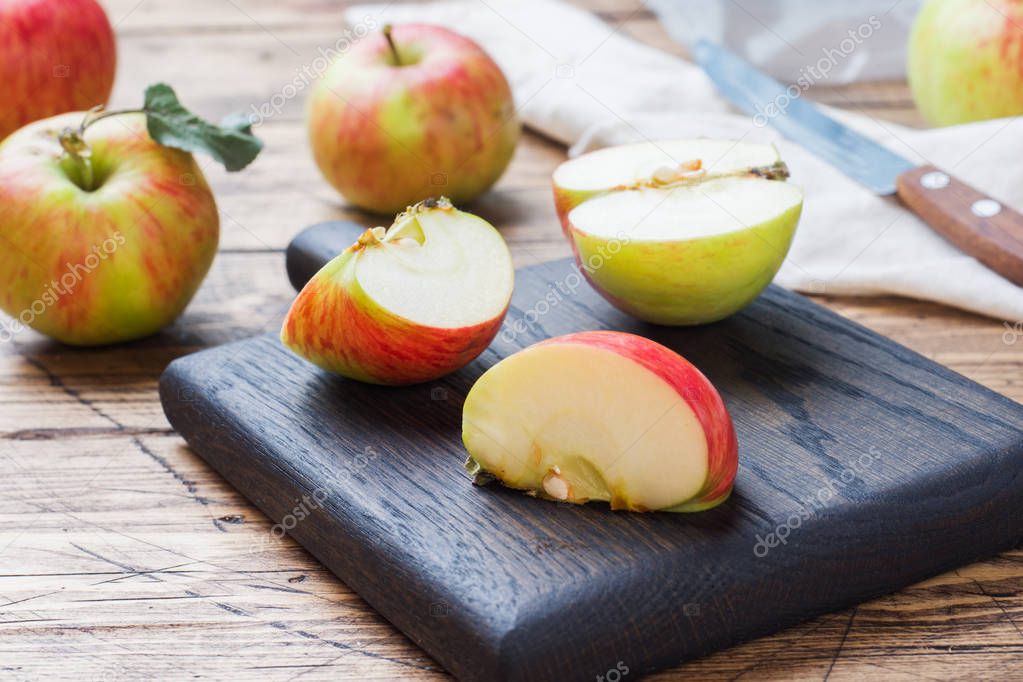 Red apples on a wooden table. Apples cut into slices. Copy space.